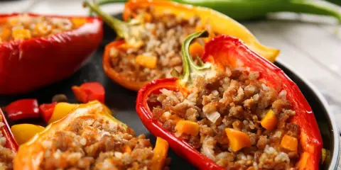 Peperoni ripieni senza carne, un piatto colorato e saporito. Peperoni rossi, gialli e arancioni farciti con un gustoso ripieno.