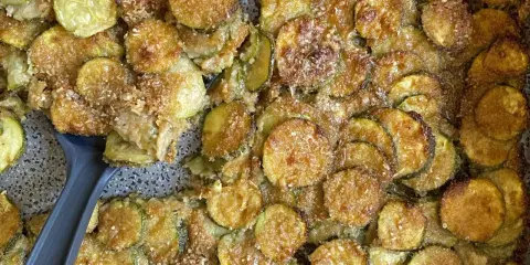 Fette di zucchine gratinate al forno, dorate e croccanti, pronte per essere servite.