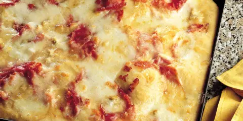 Pizza di patate filante con prosciutto croccante, un piatto invitante e gustoso.