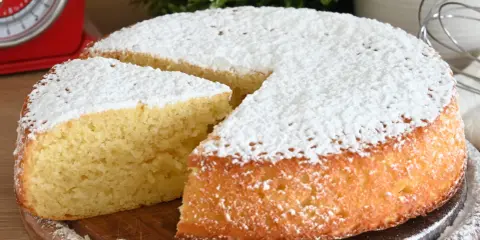 Una fetta di torta allo yogurt soffice, cosparsa di zucchero a velo, pronta per essere gustata.