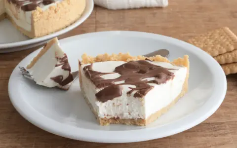 Una fetta di torta fredda allo yogurt con base croccante e golosa copertura al cioccolato.