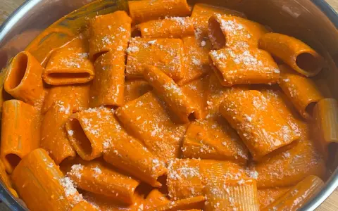 Rigatoni cremosi in salsa all'nduja, spolverati con parmigiano. Un piatto che scalda il cuore e il palato.