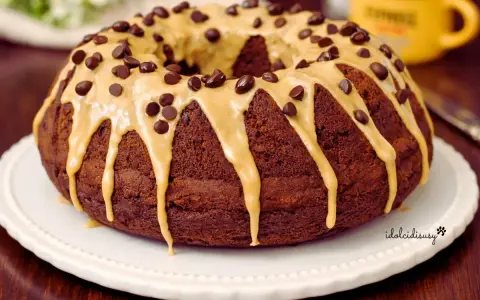 Ciambella al caffè, ricoperta da glassa caramello e gocce di cioccolato, pronta per essere gustata.