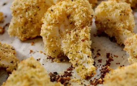 Cavolfiore al forno con pangrattato e formaggio, croccante e dorato, pronto per essere gustato.