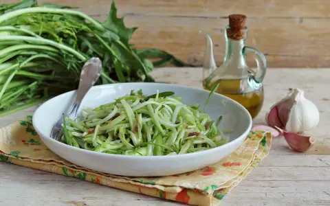 Un piatto di puntarelle alla romana, condite con olio e aglio, pronte per essere gustate.