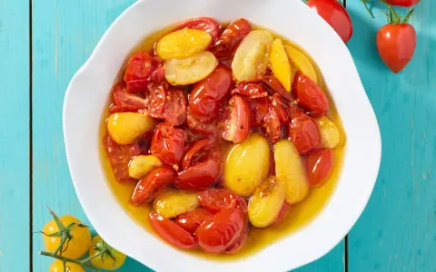 Pomodorini confit in friggitrice ad aria, rossi e gialli, succosi e dolci, pronti per insaporire ogni piatto.