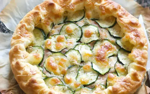 Deliziosa torta salata con zucchine, formaggio fuso e croccante pasta sfoglia. Perfetta per un pranzo leggero o un aperitivo.