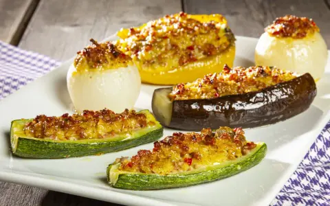 Deliziose verdure ripiene al forno: zucchine, melanzane, peperoni e cipolle dorate, un piatto invitante e saporito.