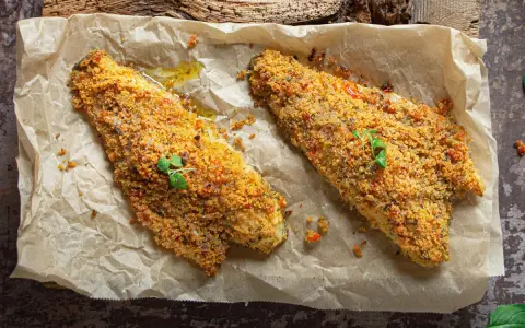 Filetti di orata al forno con crosta croccante, serviti su carta da forno.