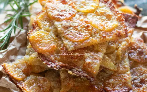 Schiacciata di patate croccante, dorata e invitante, con fette sottili di patate e un tocco di rosmarino.