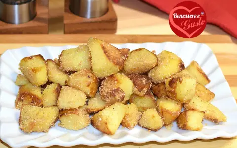 Patate sabbiose in padella, dorate e croccanti, servite su un piatto bianco. Un contorno irresistibile per ogni pasto.