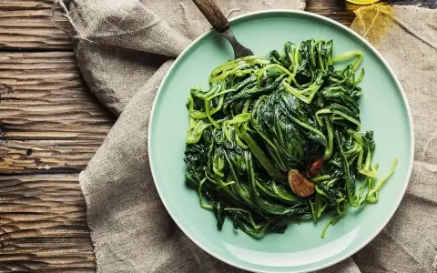 Piatto di puntarelle in padella, condite con aglio e peperoncino, pronte per essere gustate.