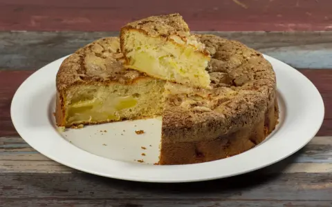 Una fetta di torta di mele, soffice e dorata, con un crumble croccante. Sembra la torta di mele più buona che abbia mai mangiato.