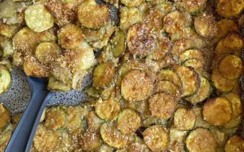 Fette di zucchine gratinate al forno, dorate e croccanti, pronte per essere servite.