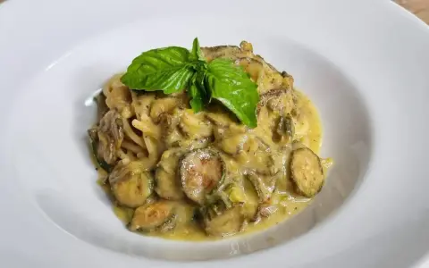 Spaghetti alla Nerano cremosi con zucchine e basilico fresco, un piatto che sa di estate.