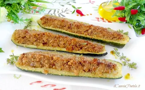 Zucchine ripiene tonno, dorate e croccanti, servite su un piatto bianco con erbe aromatiche.