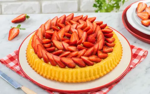 Una deliziosa crostata morbida alle fragole, ricca di frutta fresca e crema, pronta per essere gustata.