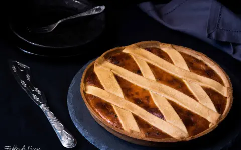Una deliziosa crostata di ricotta, con una griglia dorata di pasta frolla, pronta per essere gustata.