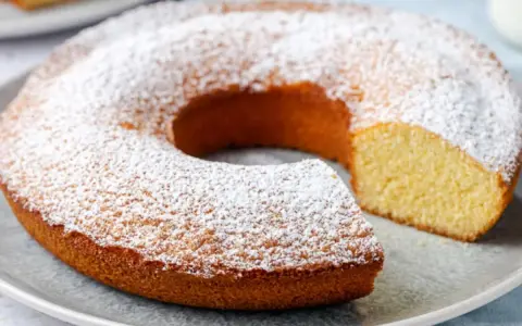 Ciambella senza glutine, soffice e dorata, cosparsa di zucchero a velo. Perfetta per una colazione o merenda golosa e leggera.