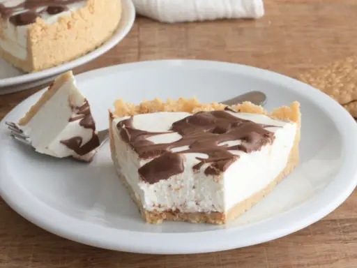Una fetta di torta fredda allo yogurt con base croccante e golosa copertura al cioccolato.