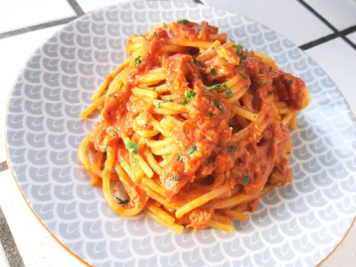 Spaghetti al tonno ricetta della nonna, un piatto gustoso e semplice, con pomodoro e tonno, guarnito con prezzemolo fresco.