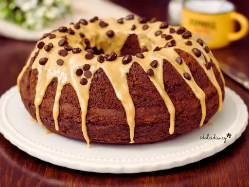 Ciambella al caffè, ricoperta da glassa caramello e gocce di cioccolato, pronta per essere gustata.