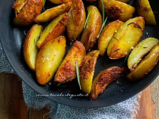 Patate in padella croccanti, dorate e profumate al rosmarino, pronte per essere gustate.