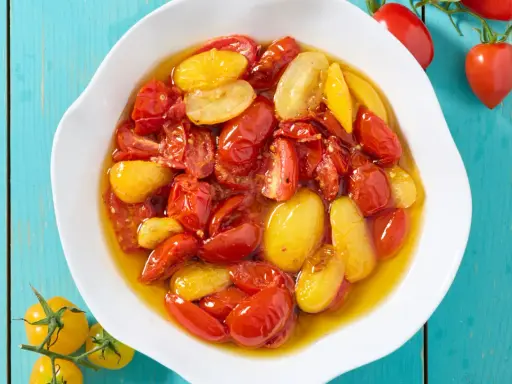 Pomodorini confit in friggitrice ad aria, rossi e gialli, succosi e dolci, pronti per insaporire ogni piatto.