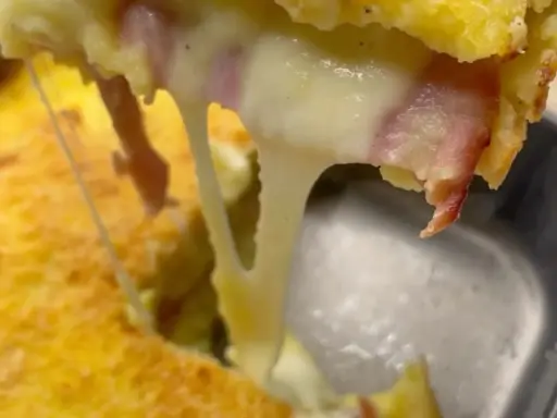 Un delizioso tortino di patate prosciutto e mozzarella filante, con la crosticina dorata e il formaggio che cola.