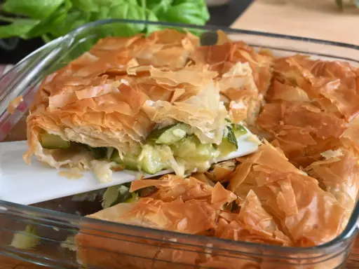 Torta salata con pasta sfoglia e zucchine, dorata e croccante, pronta per essere gustata.