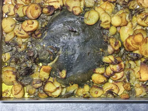 Rombo al forno con patate dorate e cipolle caramellate, un piatto succulento e profumato pronto per essere gustato.