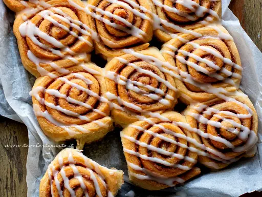 Dolci con lievito di birra, soffici girelle alla cannella con glassa bianca, pronte per essere gustate.