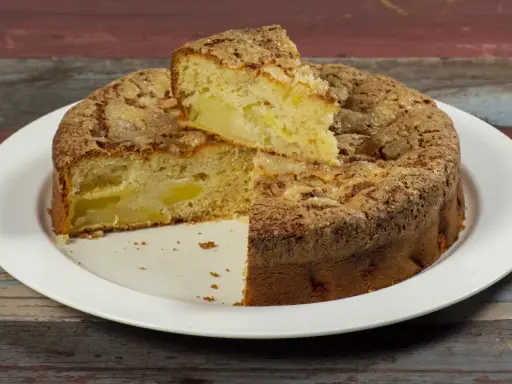 Una fetta di torta di mele, soffice e dorata, con un crumble croccante. Sembra la torta di mele più buona che abbia mai mangiato.