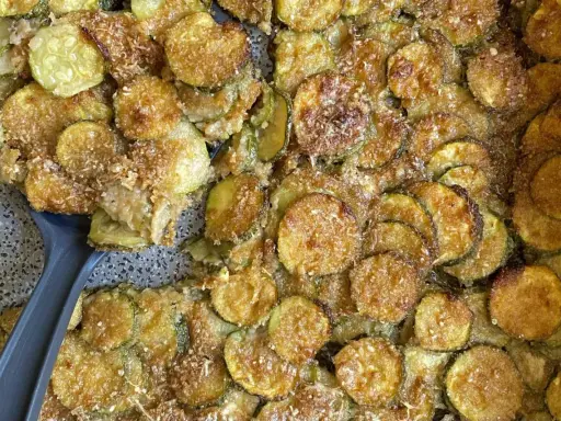 Fette di zucchine gratinate al forno, dorate e croccanti, pronte per essere servite.