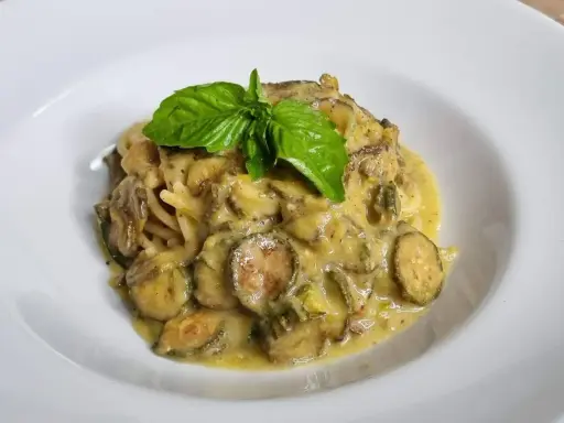 Spaghetti alla Nerano cremosi con zucchine e basilico fresco, un piatto che sa di estate.