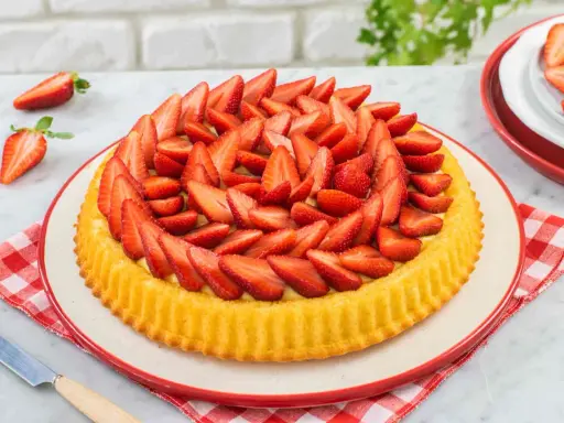 Una deliziosa crostata morbida alle fragole, ricca di frutta fresca e crema, pronta per essere gustata.