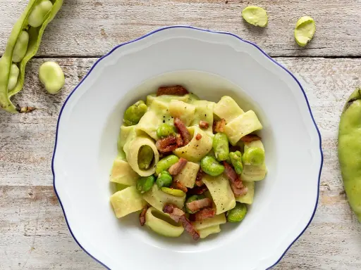 Piatto di pasta con fave fresche e croccante pancetta, un classico saporito.