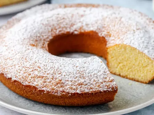 Ciambella senza glutine, soffice e dorata, cosparsa di zucchero a velo. Perfetta per una colazione o merenda golosa e leggera.