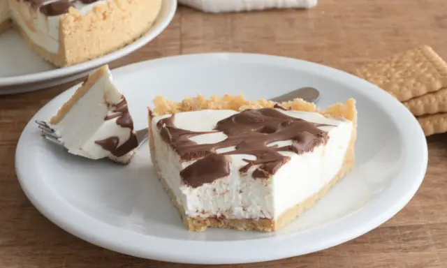 Una fetta di torta fredda allo yogurt con base croccante e golosa copertura al cioccolato.