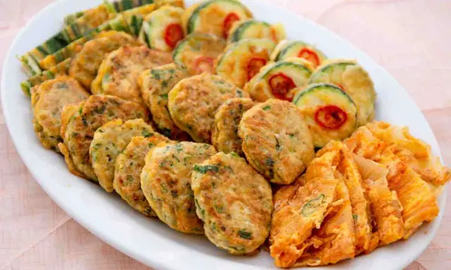 Piatto di frittelle di una volta: polpette verdi, zucchine con peperoncino e sfoglie dorate. Un tripudio di sapori e colori.