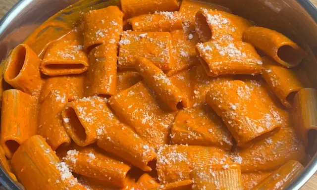 Rigatoni cremosi in salsa all'nduja, spolverati con parmigiano. Un piatto che scalda il cuore e il palato.