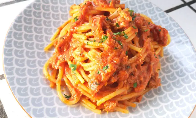 Spaghetti al tonno ricetta della nonna, un piatto gustoso e semplice, con pomodoro e tonno, guarnito con prezzemolo fresco.
