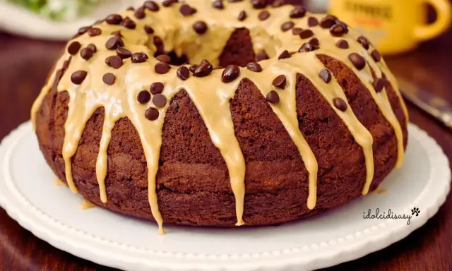 Ciambella al caffè, ricoperta da glassa caramello e gocce di cioccolato, pronta per essere gustata.