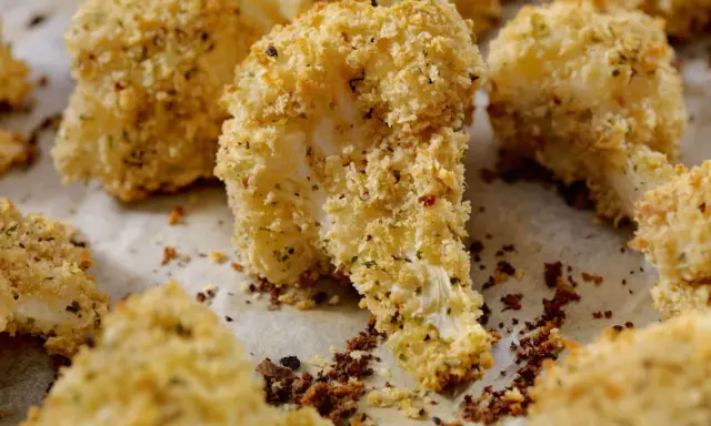 Cavolfiore al forno con pangrattato e formaggio, croccante e dorato, pronto per essere gustato.