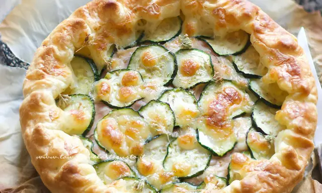 Deliziosa torta salata con zucchine, formaggio fuso e croccante pasta sfoglia. Perfetta per un pranzo leggero o un aperitivo.