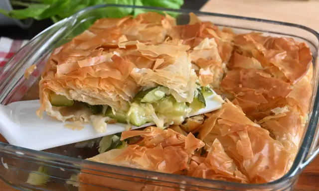 Torta salata con pasta sfoglia e zucchine, dorata e croccante, pronta per essere gustata.