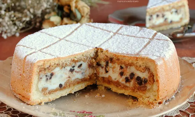 Una fetta di cassata al forno, con la sua crema vellutata e gocce di cioccolato, spolverata di zucchero a velo.