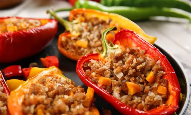 Peperoni ripieni senza carne, un piatto colorato e saporito. Peperoni rossi, gialli e arancioni farciti con un gustoso ripieno.
