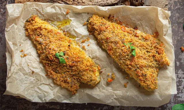 Filetti di orata al forno con crosta croccante, serviti su carta da forno.