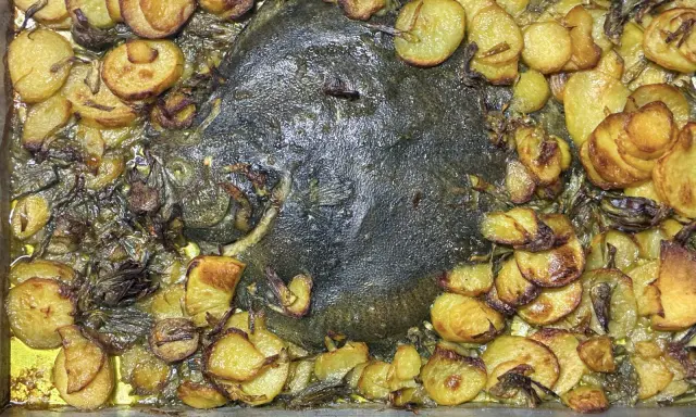 Rombo al forno con patate dorate e cipolle caramellate, un piatto succulento e profumato pronto per essere gustato.